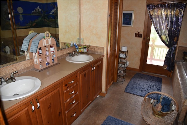 bathroom featuring tile patterned floors, baseboards, a sink, and double vanity