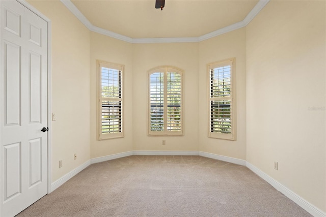 unfurnished room featuring baseboards, ornamental molding, and light carpet