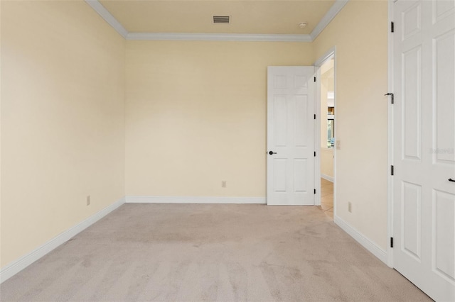 empty room featuring crown molding, visible vents, light colored carpet, and baseboards