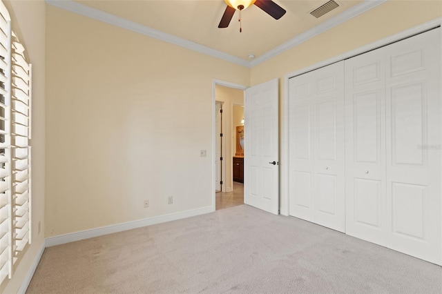 unfurnished bedroom with baseboards, visible vents, carpet floors, and crown molding