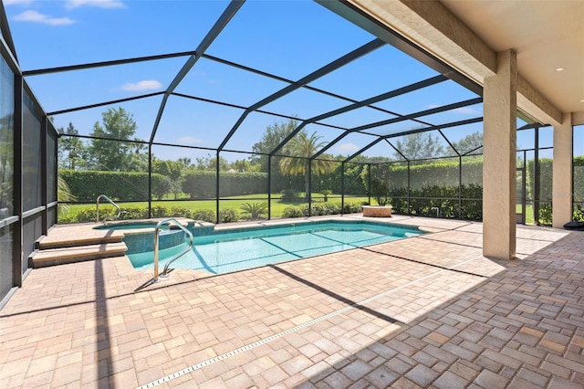 view of pool with a patio area, glass enclosure, and a pool with connected hot tub