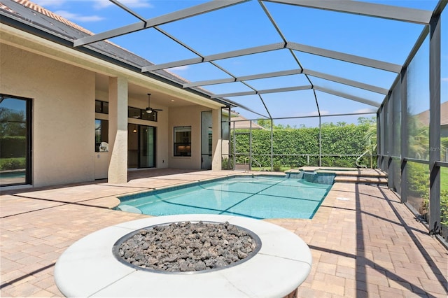 view of pool featuring ceiling fan, a patio, an outdoor fire pit, and a pool with connected hot tub