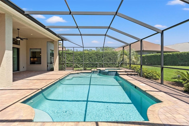 view of pool featuring a ceiling fan, glass enclosure, a pool with connected hot tub, and a patio area