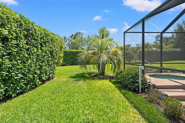 view of yard featuring an outdoor pool and glass enclosure