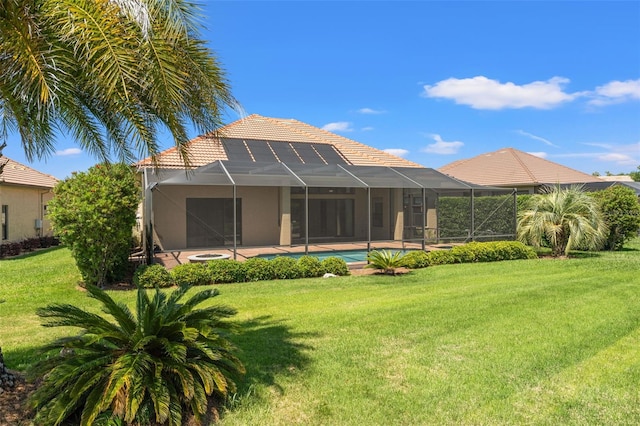 rear view of house with a tile roof, an outdoor pool, stucco siding, glass enclosure, and a lawn