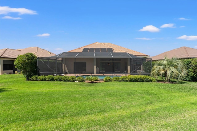 rear view of house featuring an outdoor pool, a yard, a lanai, and a tile roof