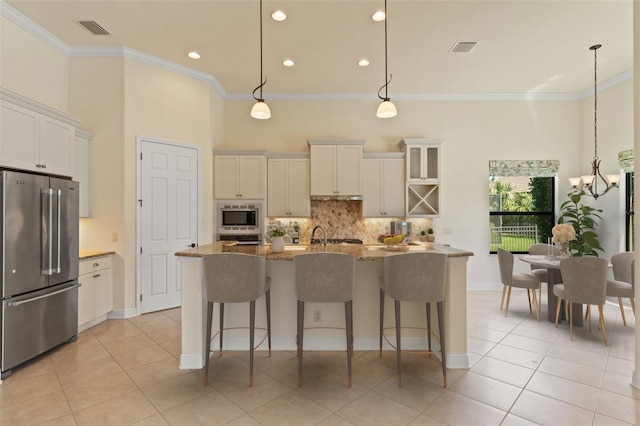 kitchen featuring appliances with stainless steel finishes, visible vents, and ornamental molding