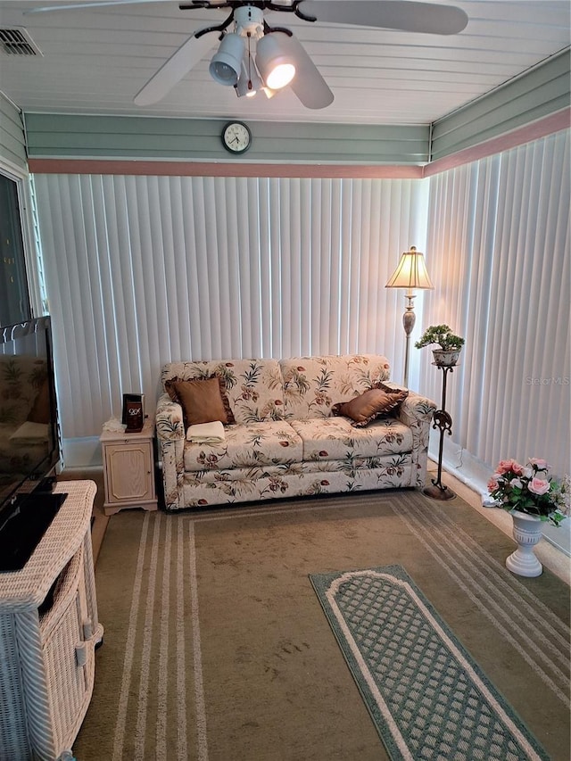 living room featuring a ceiling fan, visible vents, and carpet floors