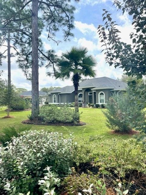 4658 W Hacienda Dr, Beverly Hills, FL 34465 - view of front of property with a front lawn and stucco siding