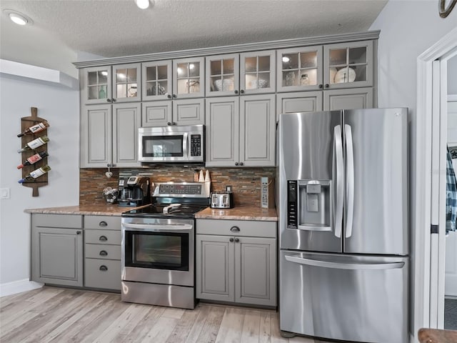 4658 W Hacienda Dr, Beverly Hills, FL 34465 - kitchen with gray cabinets, stainless steel appliances, a textured ceiling, and light wood-style flooring