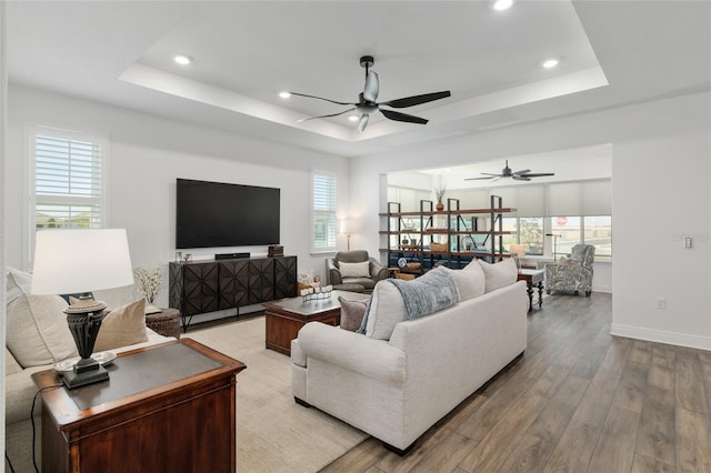 9764 SW 81st Ln, Ocala, FL 34481 - living room with a ceiling fan, a tray ceiling, recessed lighting, and light wood-style floors