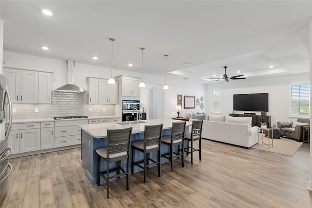 9764 SW 81st Ln, Ocala, FL 34481 - kitchen featuring wall chimney exhaust hood, stainless steel appliances, a breakfast bar, and light wood-style flooring