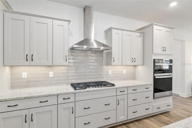 9764 SW 81st Ln, Ocala, FL 34481 - kitchen featuring light wood-type flooring, decorative backsplash, wall chimney range hood, light stone countertops, and appliances with stainless steel finishes