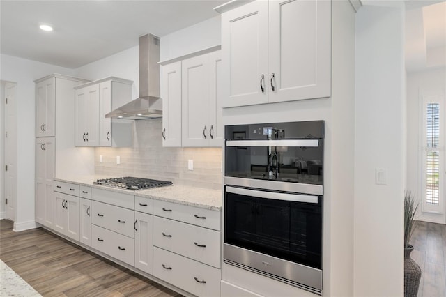 9764 SW 81st Ln, Ocala, FL 34481 - kitchen featuring light wood finished floors, stainless steel appliances, light stone countertops, wall chimney exhaust hood, and tasteful backsplash