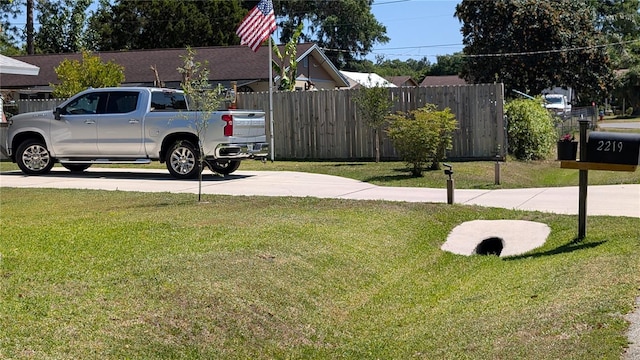 view of yard with driveway and fence
