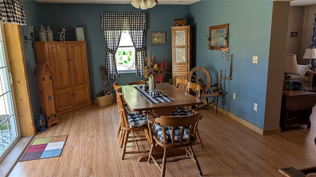 dining room featuring light wood-type flooring and baseboards