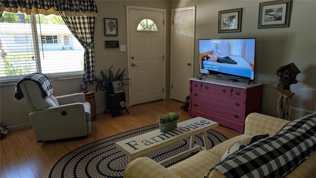 living room featuring wood finished floors, visible vents, and baseboards