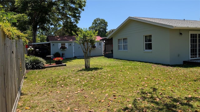 view of yard with fence and an outbuilding