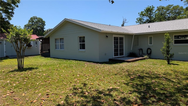 rear view of house with a storage unit, an outdoor structure, and a yard