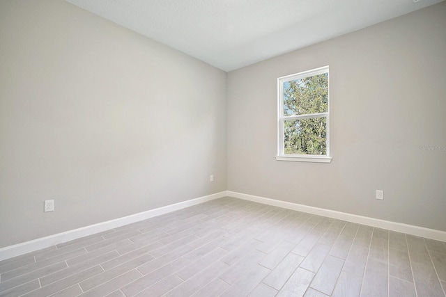 unfurnished room featuring light wood finished floors and baseboards