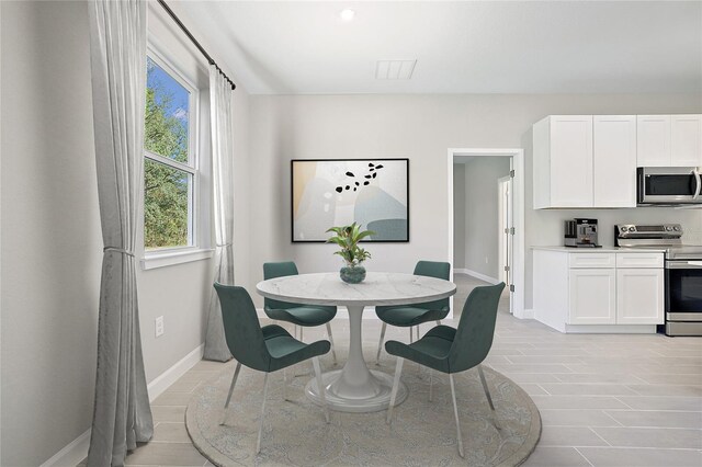 dining space featuring baseboards and visible vents
