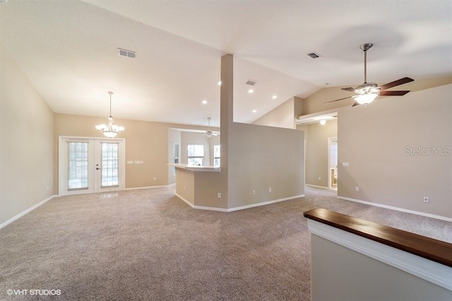 spare room featuring vaulted ceiling, visible vents, carpet flooring, and ceiling fan with notable chandelier