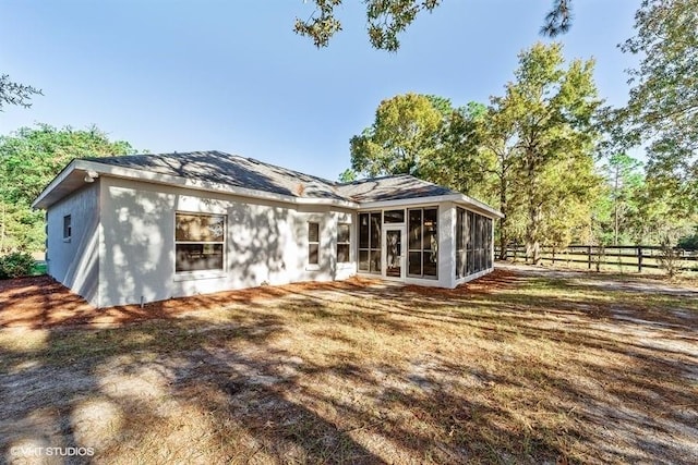 back of property featuring fence and a sunroom