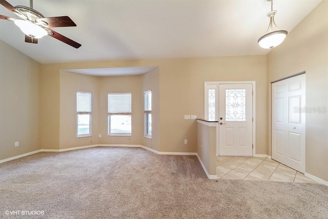 entryway with light colored carpet, ceiling fan, and baseboards
