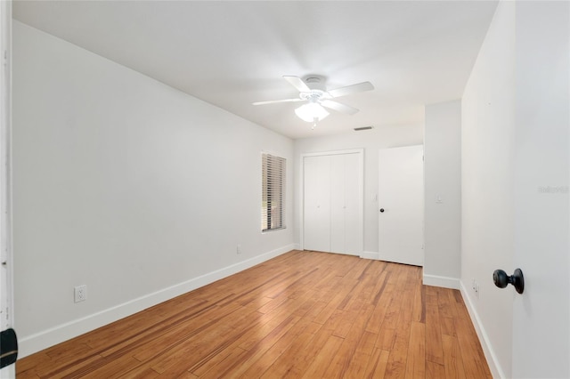 unfurnished bedroom featuring baseboards, light wood finished floors, a closet, and a ceiling fan