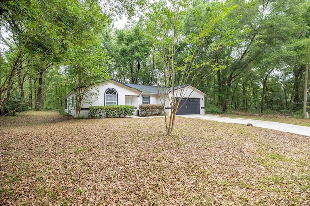 ranch-style home with stucco siding, an attached garage, and concrete driveway