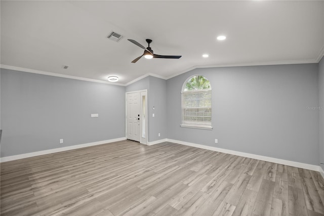 empty room featuring vaulted ceiling, wood finished floors, visible vents, baseboards, and ceiling fan