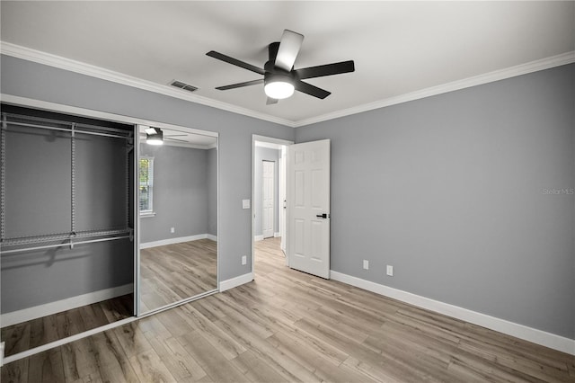 unfurnished bedroom with baseboards, wood finished floors, visible vents, and crown molding