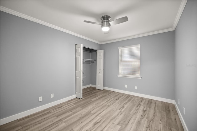 unfurnished bedroom featuring wood finished floors, a closet, ceiling fan, baseboards, and ornamental molding