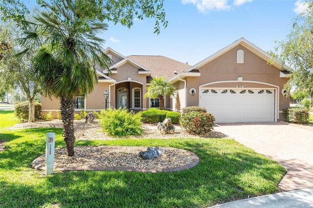 8632 SW 86th Cir, Ocala, FL 34481 - view of front facade with a garage, stucco siding, driveway, and a front lawn