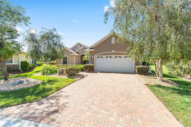 8632 SW 86th Cir, Ocala, FL 34481 - view of front of home with an attached garage, decorative driveway, stucco siding, and a front yard