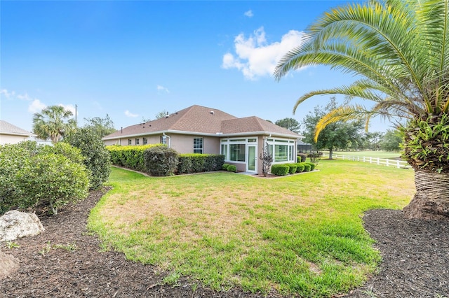 8632 SW 86th Cir, Ocala, FL 34481 - rear view of house featuring a sunroom, a lawn, fence, and stucco siding