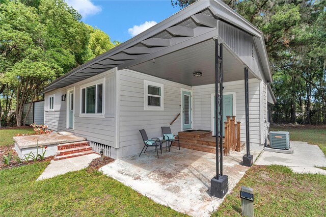 4180 W Anthony Rd, Ocala, FL 34475 - rear view of property featuring a lawn, central AC, and a patio