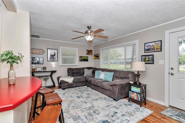 4180 W Anthony Rd, Ocala, FL 34475 - living room with wood finished floors, a textured ceiling, ceiling fan, and a healthy amount of sunlight