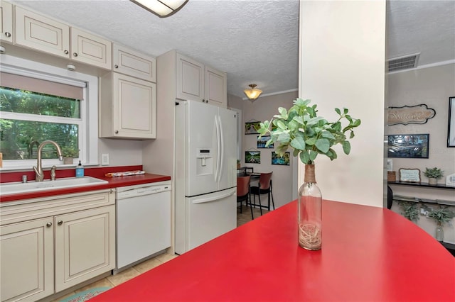 4180 W Anthony Rd, Ocala, FL 34475 - kitchen with a sink, a textured ceiling, visible vents, white appliances, and cream cabinets