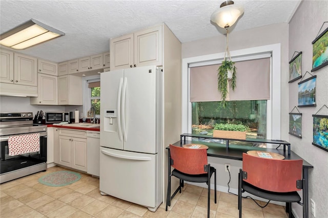 4180 W Anthony Rd, Ocala, FL 34475 - kitchen featuring stainless steel appliances, a sink, a textured ceiling, under cabinet range hood, and cream cabinets