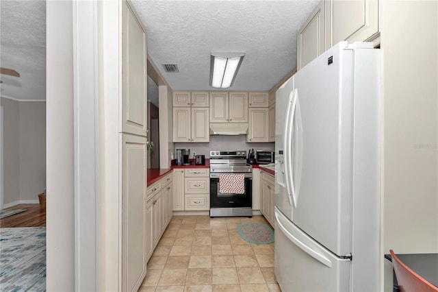 4180 W Anthony Rd, Ocala, FL 34475 - kitchen with white fridge with ice dispenser, electric range, cream cabinetry, under cabinet range hood, and visible vents
