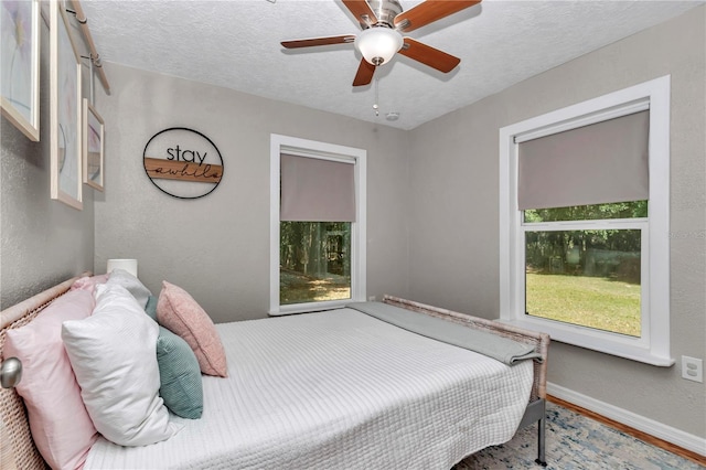 4180 W Anthony Rd, Ocala, FL 34475 - bedroom featuring a textured ceiling, baseboards, wood finished floors, ceiling fan, and a textured wall