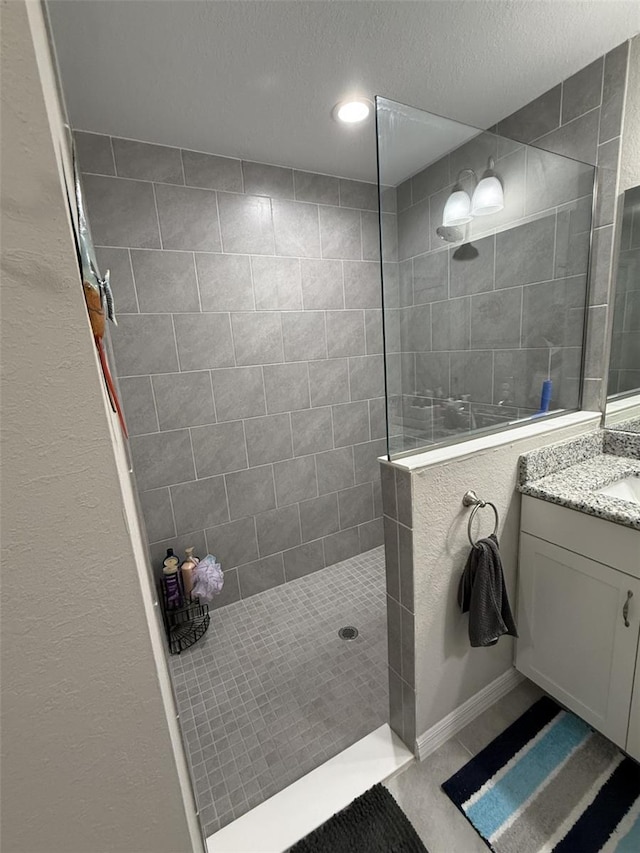 full bathroom featuring walk in shower, a textured ceiling, and vanity