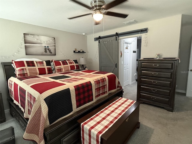 bedroom with carpet floors, a barn door, a ceiling fan, and visible vents