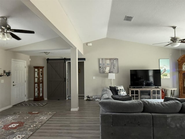 living room with lofted ceiling, wood finished floors, a barn door, ceiling fan, and baseboards