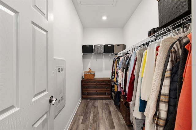 walk in closet with attic access and wood finished floors