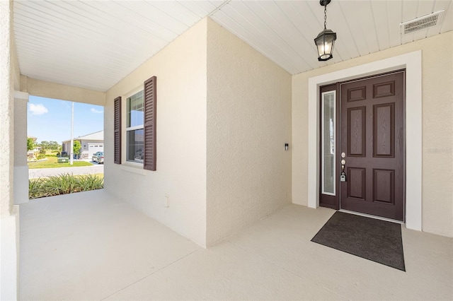 8952 SW 79th Ln, Ocala, FL 34481 - doorway to property featuring visible vents, a porch, and stucco siding