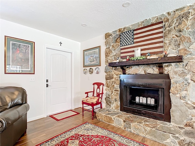 4806 SW County Road 769, Arcadia, FL 34269 - living area with a stone fireplace, baseboards, a textured ceiling, and wood finished floors