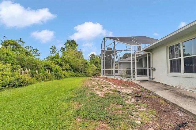 view of green lawn featuring a patio and a lanai