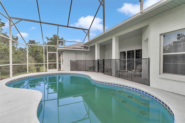 swimming pool featuring glass enclosure and a patio